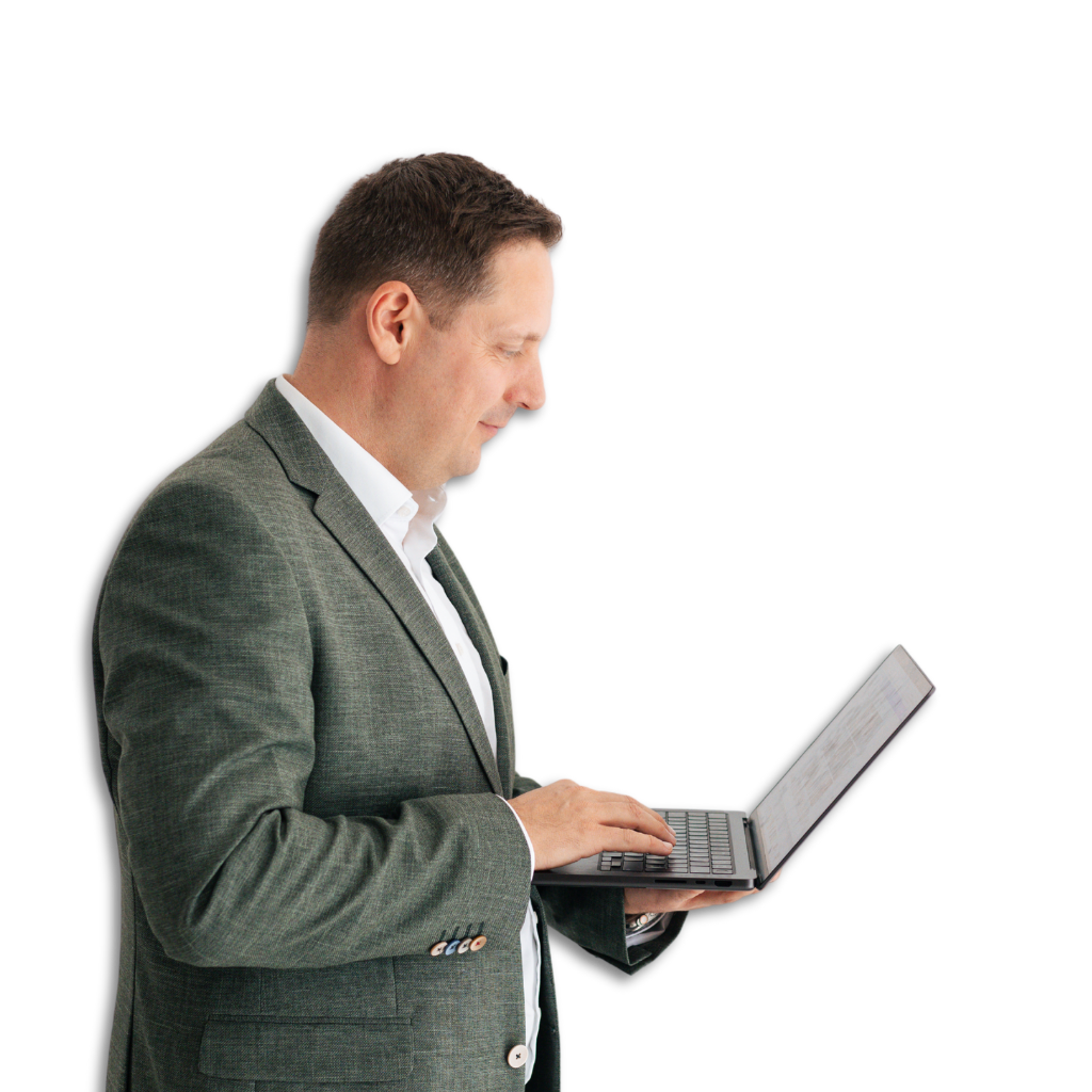 Leaderchip Coach Timo Pregler im Anzug mit einem Laptop in der Hand